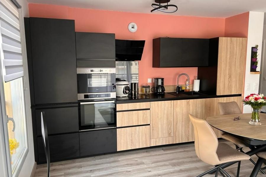 Cuisine noire et bois avec mur coloré, une cuisine réalisée par SoCoo'c Melun
