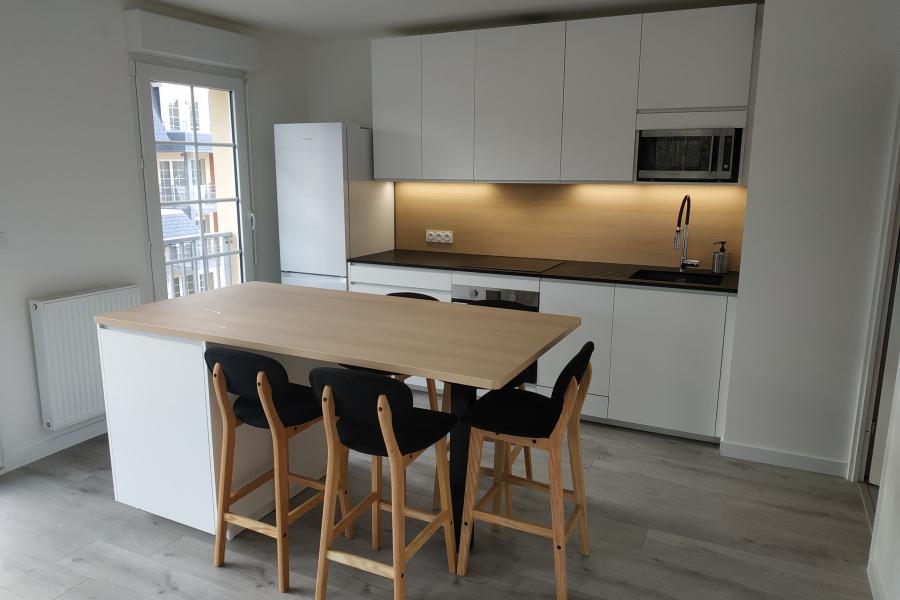 Une cuisine blanche et bois avec coin repas, une cuisine réalisée par SoCoo'c Deauville