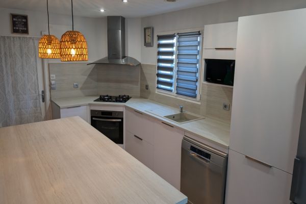 Cuisine blanche et son plan de travail travertin, une cuisine réalisée par SoCoo'c Nîmes