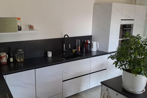 Cuisine avec du granit noir et des poignées intégrées, une cuisine réalisée par SoCoo'c Roanne