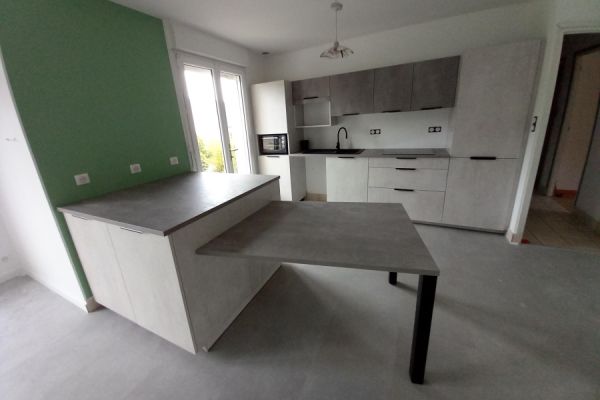 Cuisine linéaire avec îlot et coin repas – Béton clair , une cuisine réalisée par SoCoo'c Laval