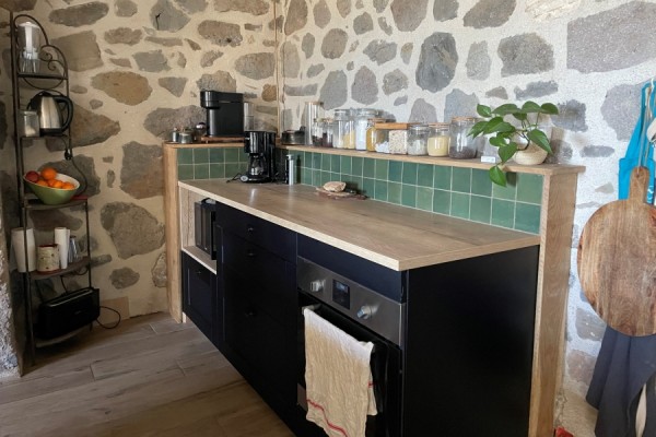 Cuisine noire et bois avec coin repas, une cuisine réalisée par SoCoo'c Aurillac