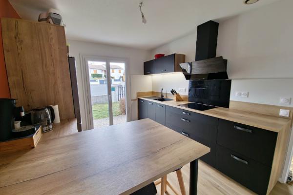 Cuisine noire et bois avec coin repas, une cuisine réalisée par SoCoo'c Aurillac