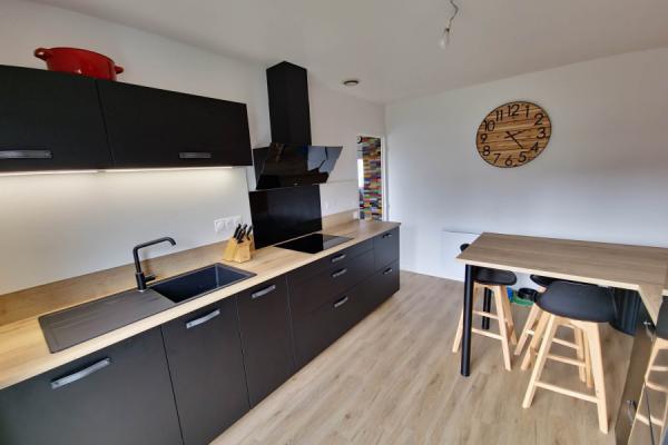 Cuisine noire et bois avec coin repas, une cuisine réalisée par SoCoo'c Aurillac