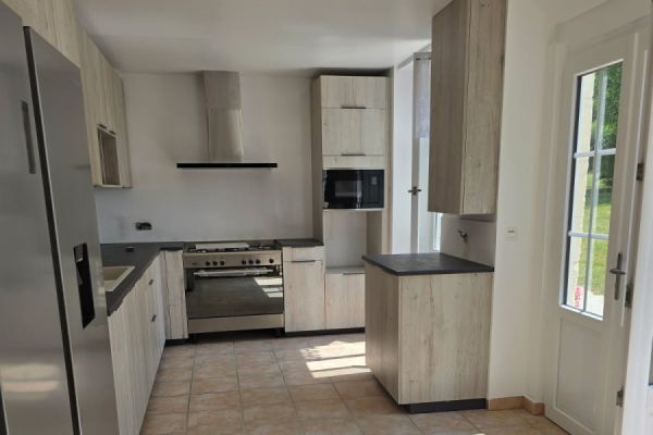 Une cuisine en bois avec du rangement jusqu'au plafond, une cuisine réalisée par SoCoo'c Saintes