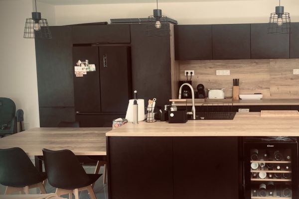 Cuisine noire et bois avec coin repas / îlot chez Julie, une cuisine réalisée par SoCoo'c Amberieu