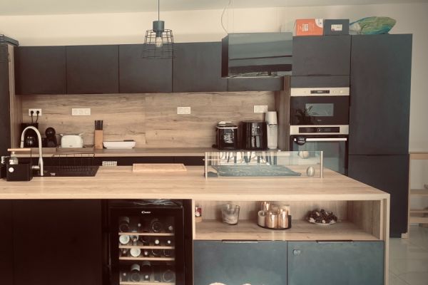 Cuisine noire et bois avec coin repas / îlot chez Julie, une cuisine réalisée par SoCoo'c Amberieu