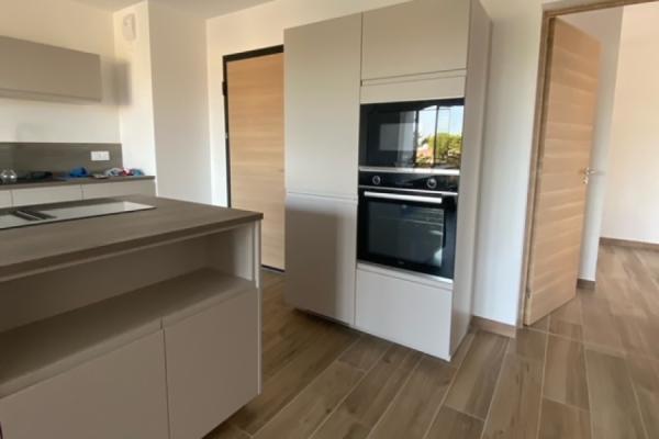Cuisine blanche et beige avec îlot, une cuisine réalisée par SoCoo'c Bastia