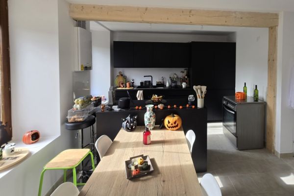 Cuisine équipée noire avec ilot et table, une cuisine réalisée par SoCoo'c Charleville