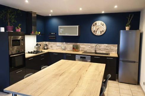 Cuisine noire et bois avec mur bleu, une cuisine réalisée par SoCoo'c Albi