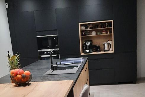 Une cuisine noire et bois avec son îlot, une cuisine réalisée par SoCoo'c Aurillac