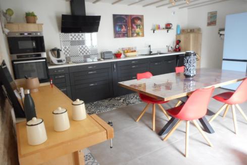 Cuisine noire et blanche avec coin repas, une cuisine réalisée par SoCoo'c Saintes
